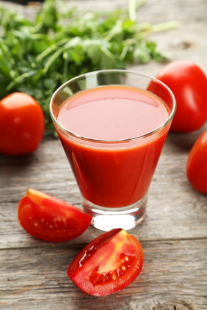 Glass of tomato juice on grey wooden backgroundの写真素材