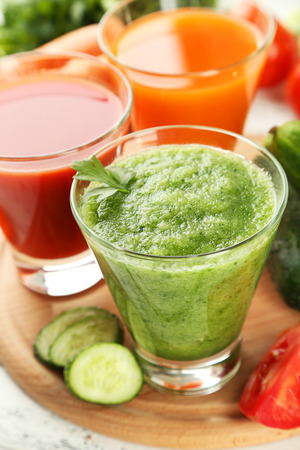Fresh tomato, carrot and cucumber juice on white wooden backgroundの写真素材