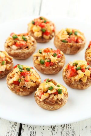 Stuffed mushrooms on plate on white wooden backgroundの写真素材