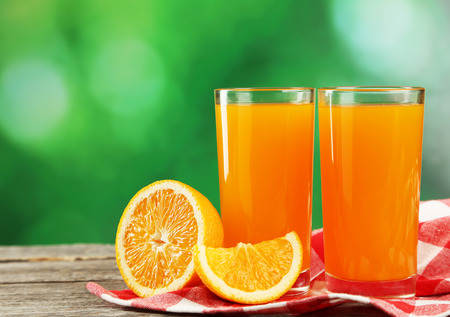 Glass of fresh orange juice on grey wooden backgroundの写真素材