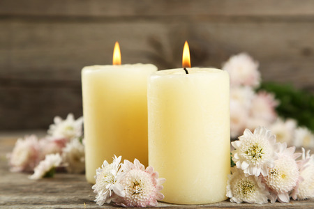 Beautiful white chrysanthemums with candles on grey wooden backgroundの写真素材