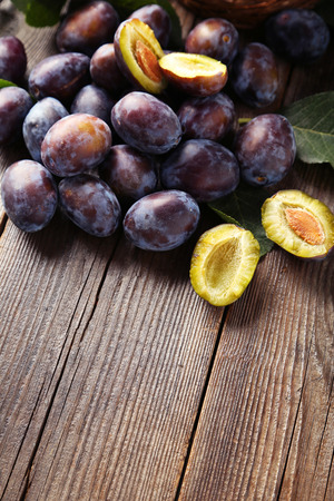 Fresh plums on brown wooden backgroundの写真素材