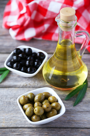 Green and black olives in bowl on grey wooden backgroundの写真素材