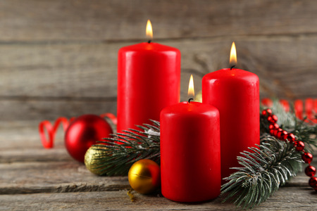 Branch of Christmas tree with balls and candles on grey wooden backgroundの写真素材