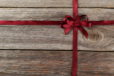 Burgundy ribbon with bow on grey wooden backgroundの写真素材