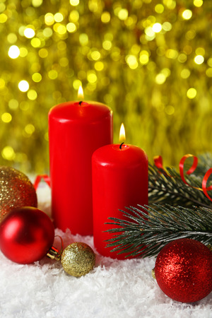 Branch of Christmas tree with balls and candles on snowの写真素材