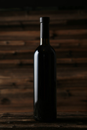 Bottle of red wine on brown wooden backgroundの写真素材