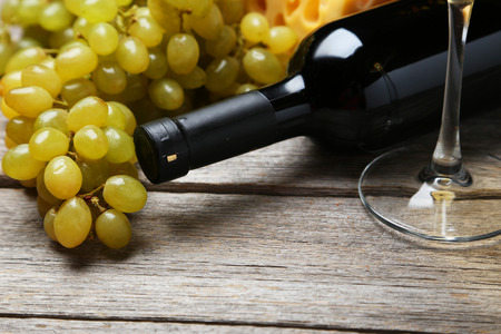 Bottle of white wine with grapes on grey wooden backgroundの写真素材