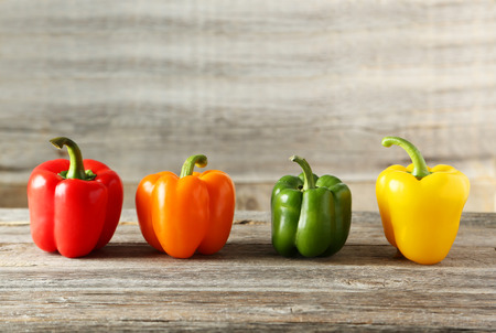 Four fresh pepper on grey wooden backgroundの写真素材