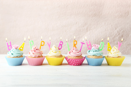 Birthday cupcakes with candles on white wooden backgroundの写真素材