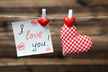 Love hearts hanging on rope on brown wooden backgroundの写真素材