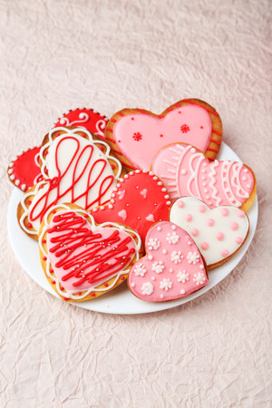 Heart cookies on white plate on pink paper backgroundの写真素材