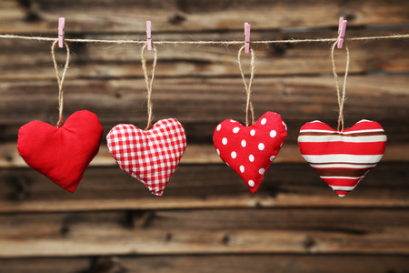 Love hearts hanging on rope on brown wooden backgroundの写真素材