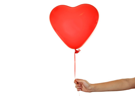 Hand holding a red heart balloon isolated on whiteの写真素材
