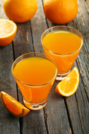 Glass of fresh orange juice on wooden backgroundの写真素材