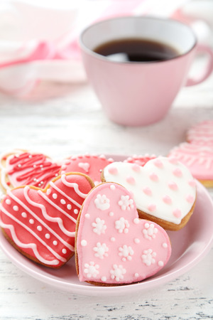 Heart cookies with cup of coffee on white wooden backgroundの写真素材