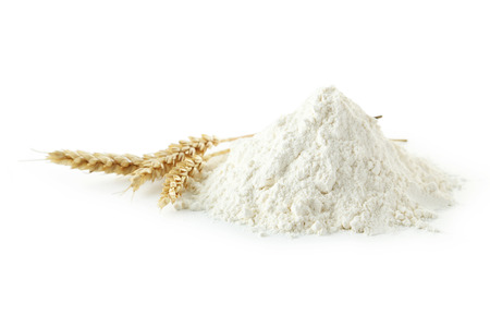 Heap of wheat flour with spikelets isolated on whiteの写真素材