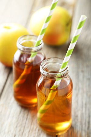 Bottle of apple juice on grey wooden backgroundの写真素材