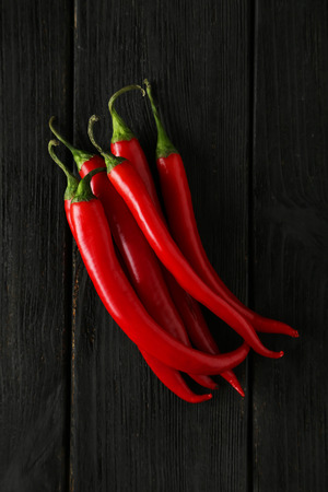 Red chili pepper on black wooden backgroundの写真素材