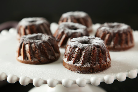 Chocolate bundt cakes on cake stand on black backgroundの写真素材