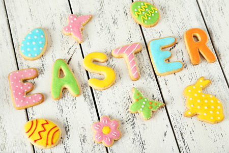 Colorful easter cookies on white wooden background