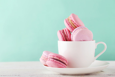 French macarons in cup on white wooden background.Toned imageの写真素材
