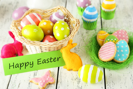 Easter eggs in basket on white wooden background