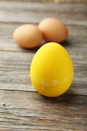 Yellow egg timer on grey wooden backgroundの写真素材