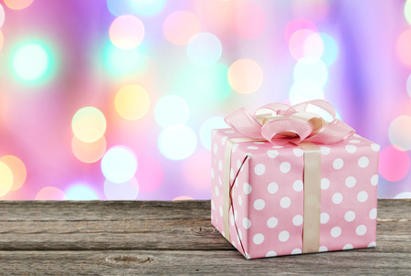 Gift box with pink bow on grey wooden backgroundの写真素材