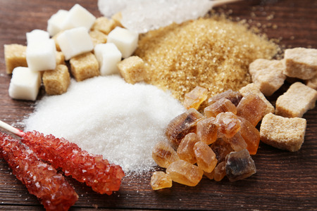 Various kinds of sugar on brown wooden backgroundの写真素材