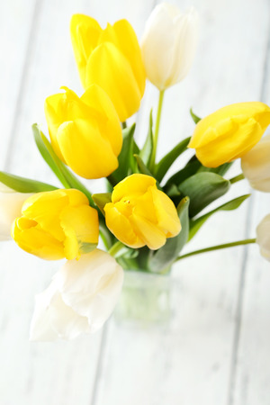 Beautiful tulips in vase on white wooden backgroundの写真素材