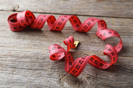 Measuring tape on grey wooden backgroundの写真素材