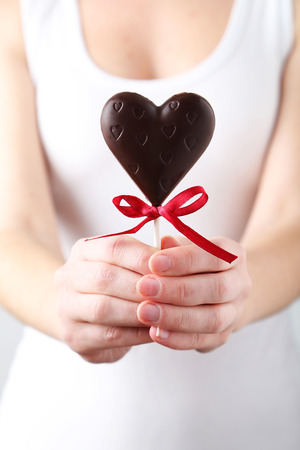 Woman's hands holding chocolate heartの写真素材