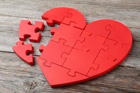 Red puzzle heart on grey wooden backgroundの写真素材