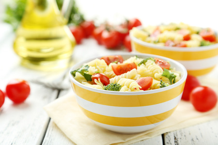 Delicious pasta in bowl on white wooden backgroundの写真素材