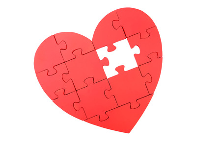 Red puzzle heart isolated on whiteの写真素材