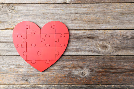 Red puzzle heart on grey wooden backgroundの写真素材