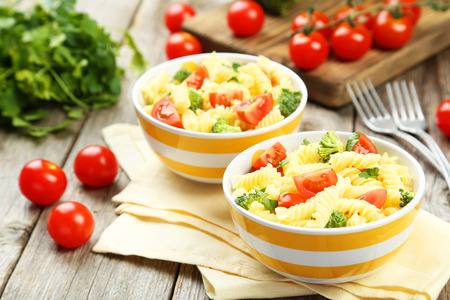 Delicious pasta in bowls on grey wooden backgroundの写真素材