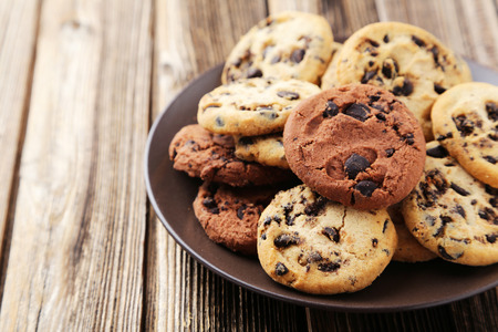 Chocolate chip cookies on plate on brown wooden backgroundの写真素材