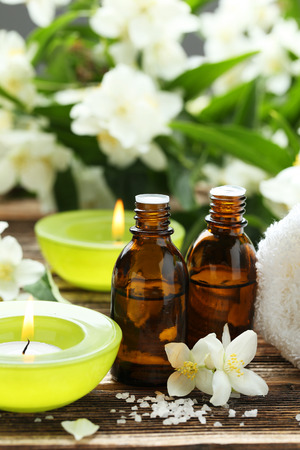 Spa oil bottles with candles on brown wooden backgroundの写真素材