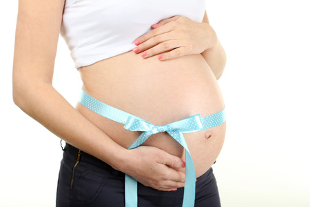 Belly of pregnant woman with blue ribbon on white background