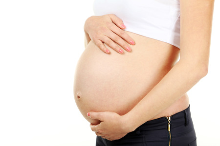 Belly of pregnant woman on white background