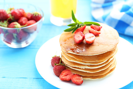 Tasty pancakes with strawberry on blue wooden backgroundの写真素材