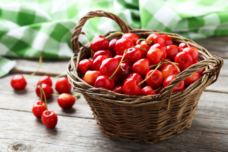 Ripe cherries in basket on grey wooden backgroundの写真素材