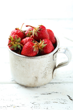 Strawberries berry in cup on white wooden backgroundの写真素材