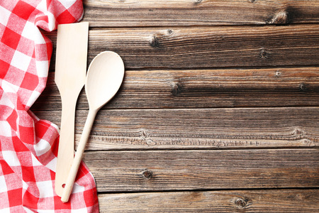 Empty wooden table with wooden spoon and napkin on brown backgroundの写真素材