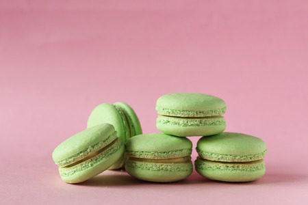 Green macarons on pink paper backgroundの写真素材