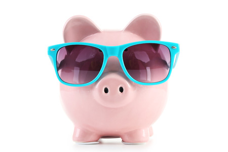 Pink piggy bank with glasses isolated on a whiteの写真素材