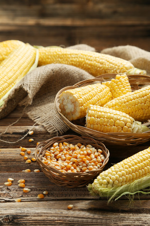 Corns in basket on a brown wooden backgroundの写真素材