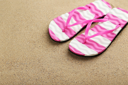 Pair of flip flops on sand beachの写真素材